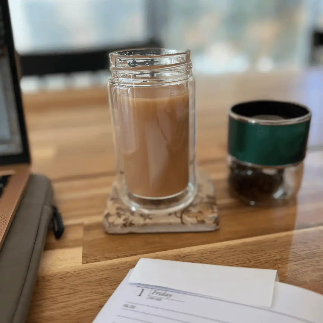 Handcrafted double-wall glass tea infuser bottle with freshly brewed coffee.