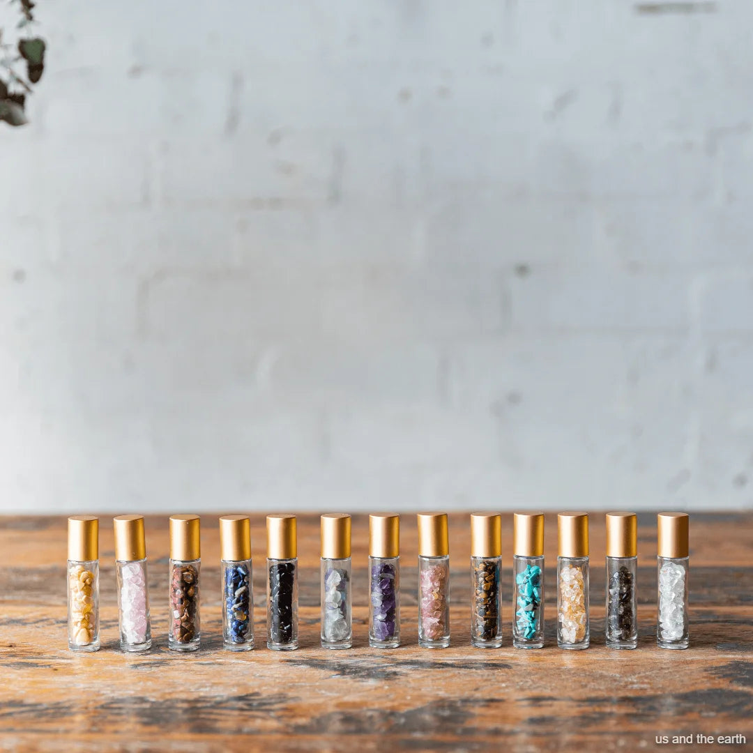 A collection of 13 essential oil crystal gemstone roller bottles in various variants from - Us and The Earth.