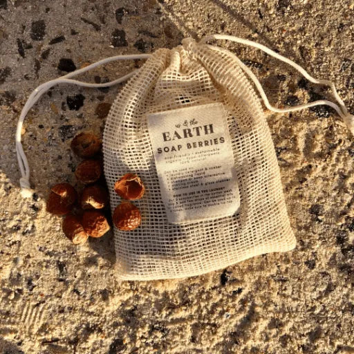 Soap berries stored in a pouch surrounded by sand, a natural and sustainable laundry solution by Us and The Earth.