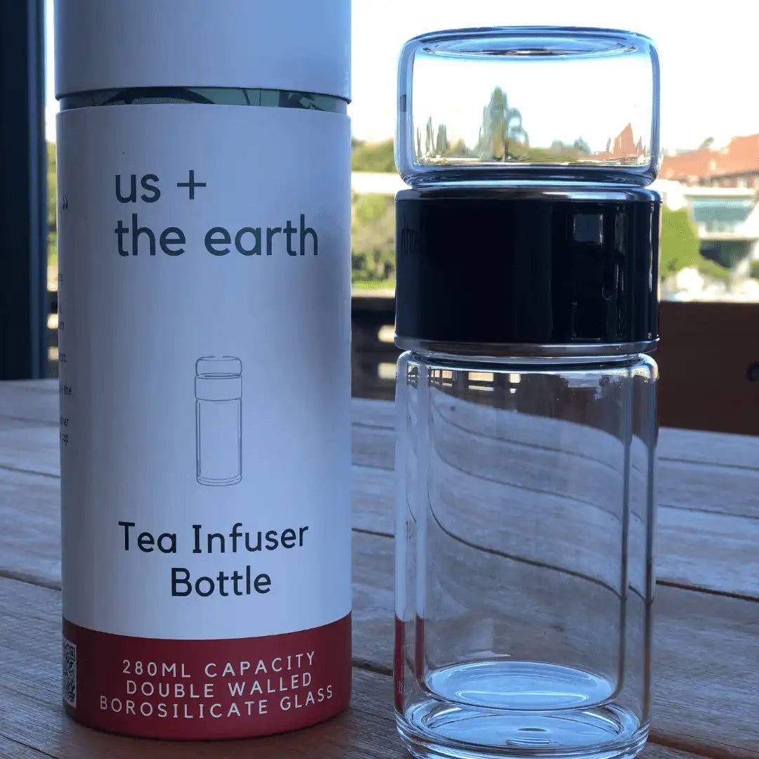 Black double wall glass tea infusing bottle placed upside down next to its branded box.