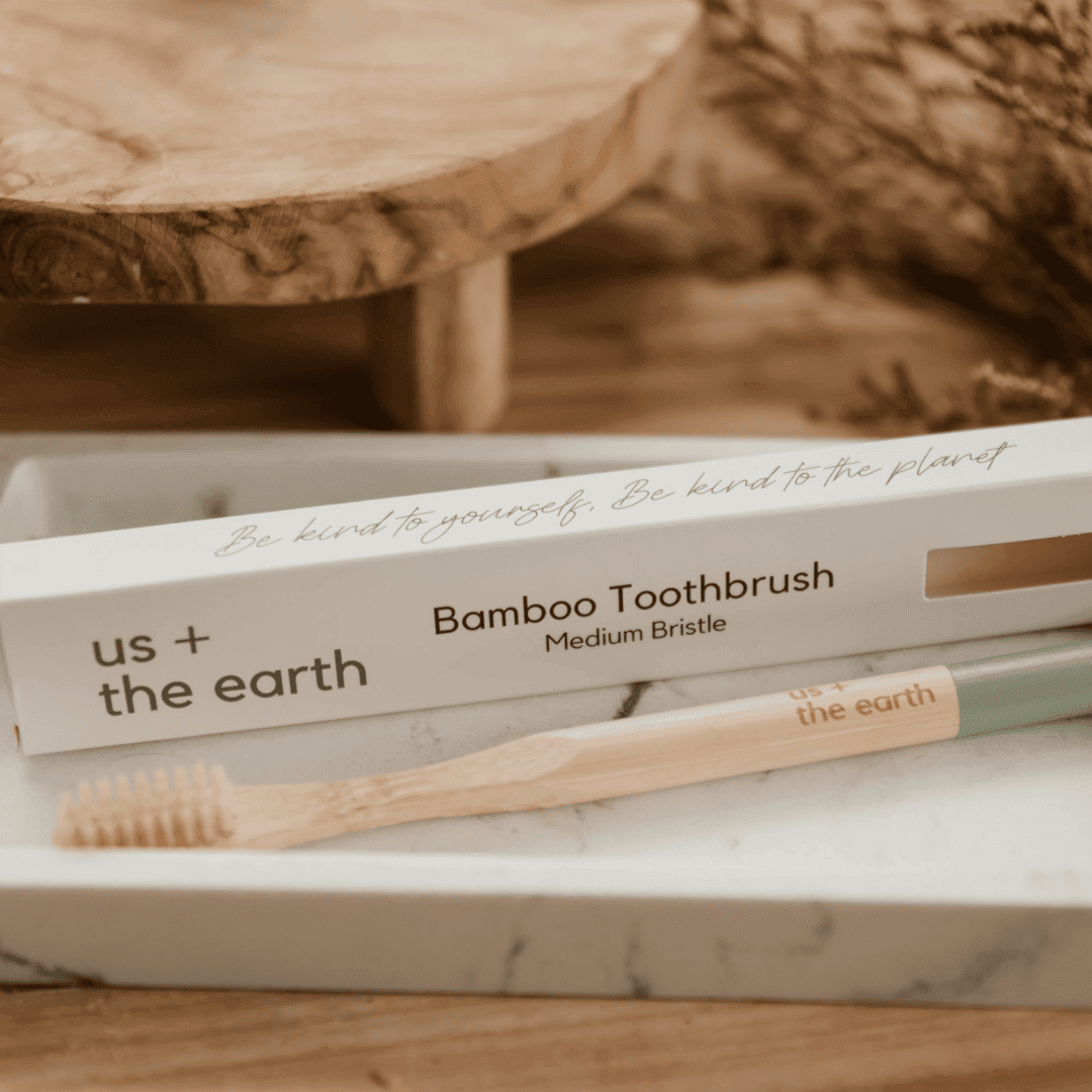 Natural bamboo toothebrush with Medium bristles in a branded Us and the Earth Kraft box