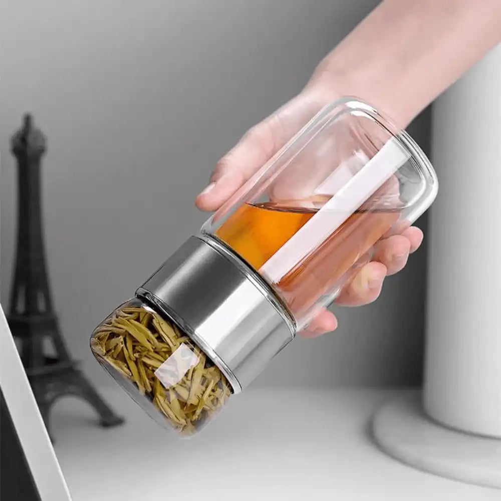 Silver tea bottle being shaken upside down for a refreshing tea experience on Us and The Earth.